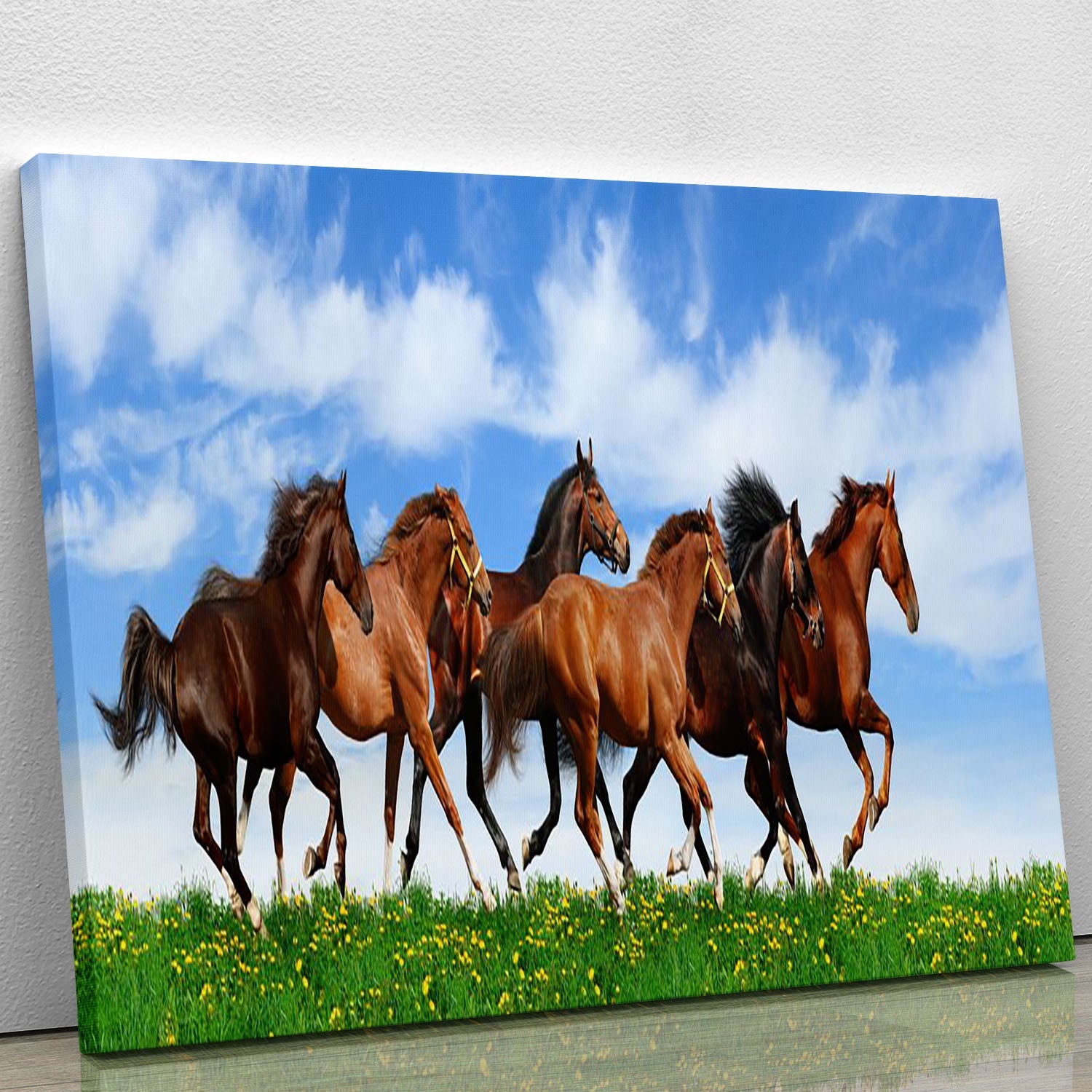 A vibrant canvas print depicting a herd of galloping horses in a lush green field, showcasing the beauty of nature.