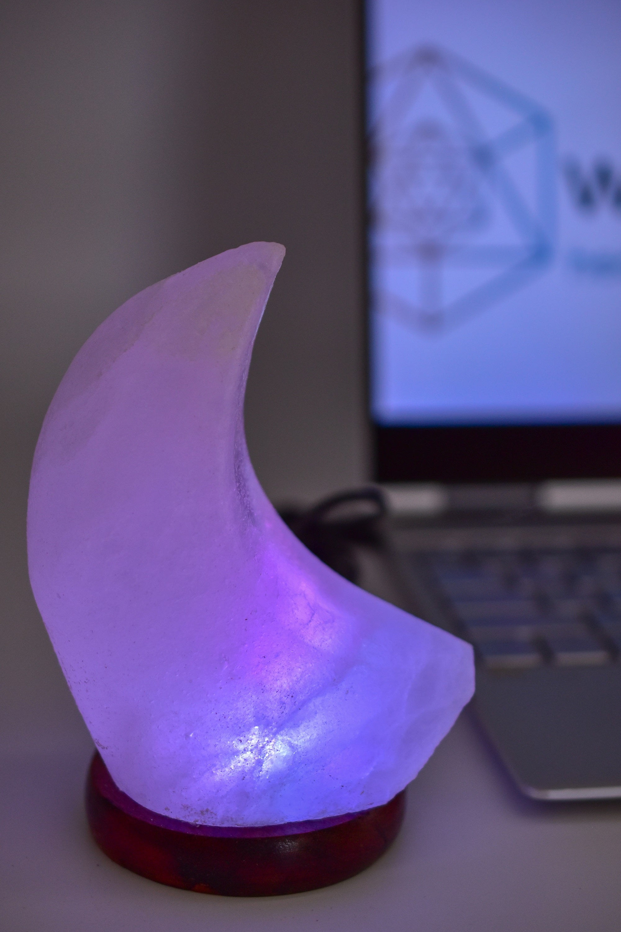 A beautifully handcrafted Himalayan Salt Moon Lamp glowing softly in various colors, showcasing its unique texture and design.