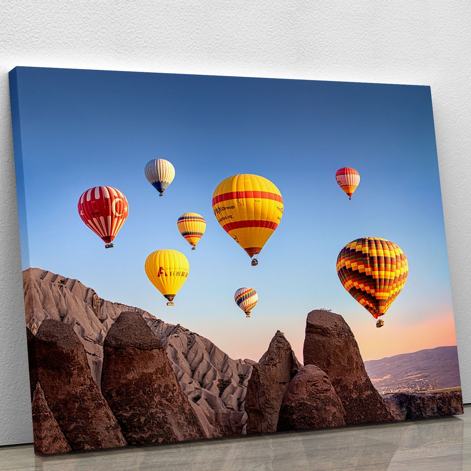 A vibrant canvas print of colorful hot air balloons floating in a clear blue sky, perfect for home or office decor.