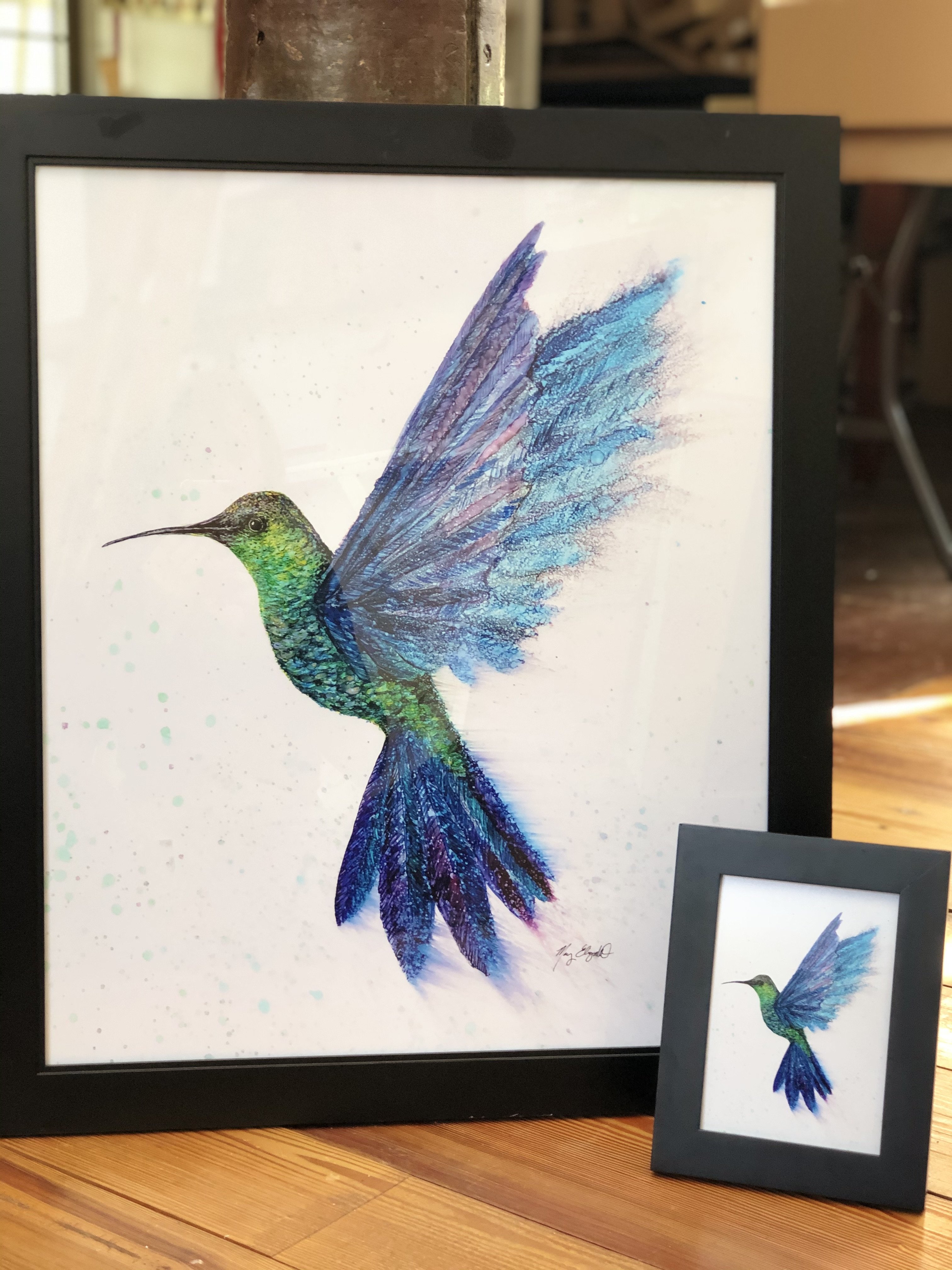 A vibrant art print of a hummingbird in flight, showcasing intricate details and colors created with alcohol inks.