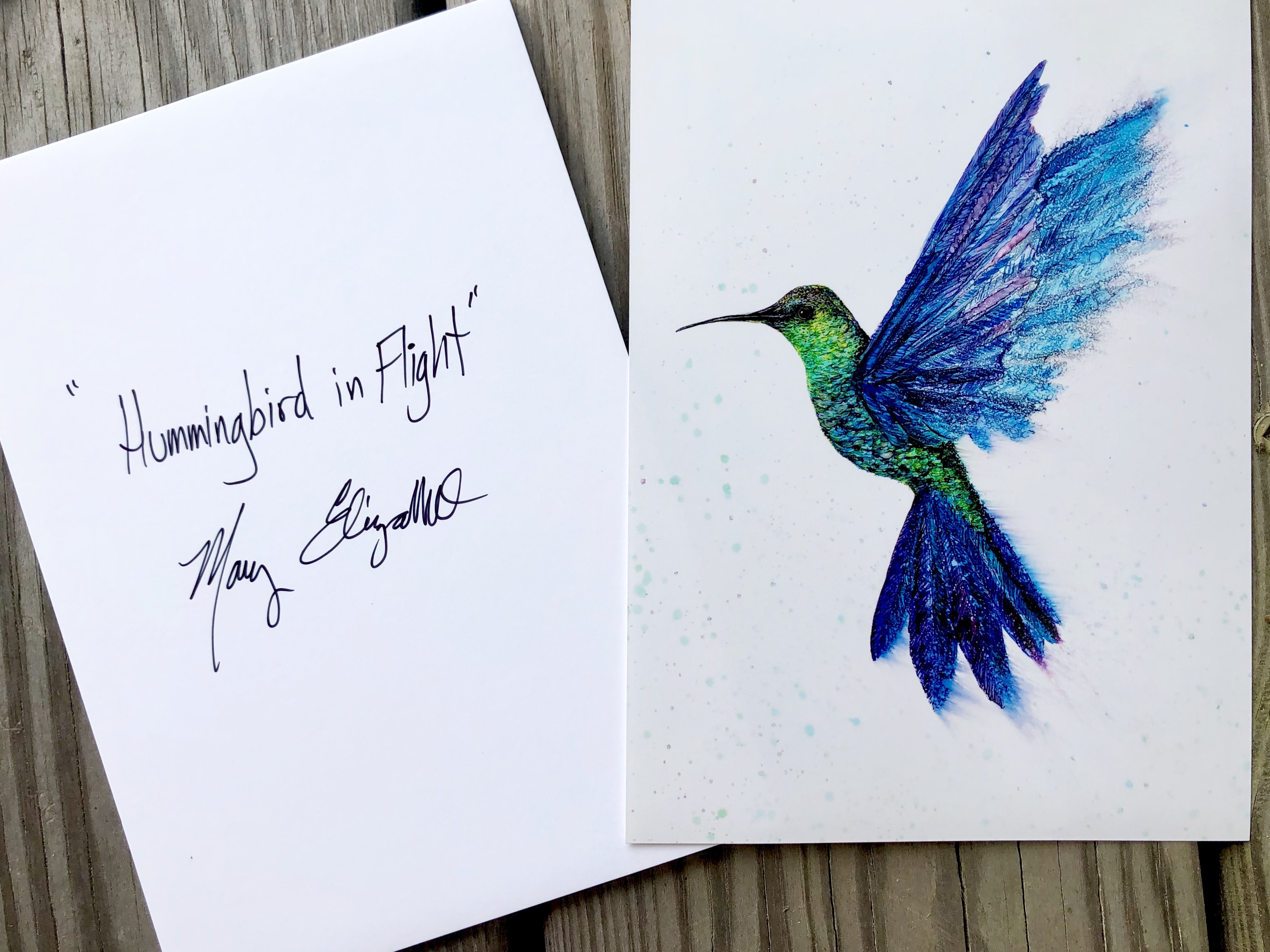 A vibrant art print of a hummingbird in flight, showcasing intricate details and colors created with alcohol inks.