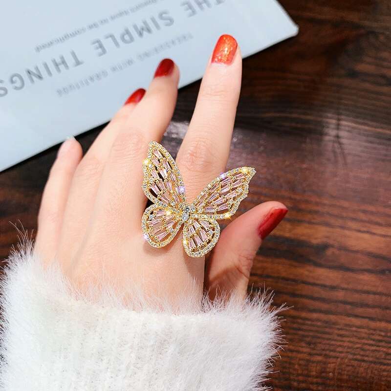 Iced out butterfly ring for women featuring luxury designer bling in white and pink colors, crafted from alloy and zircon with adjustable size.