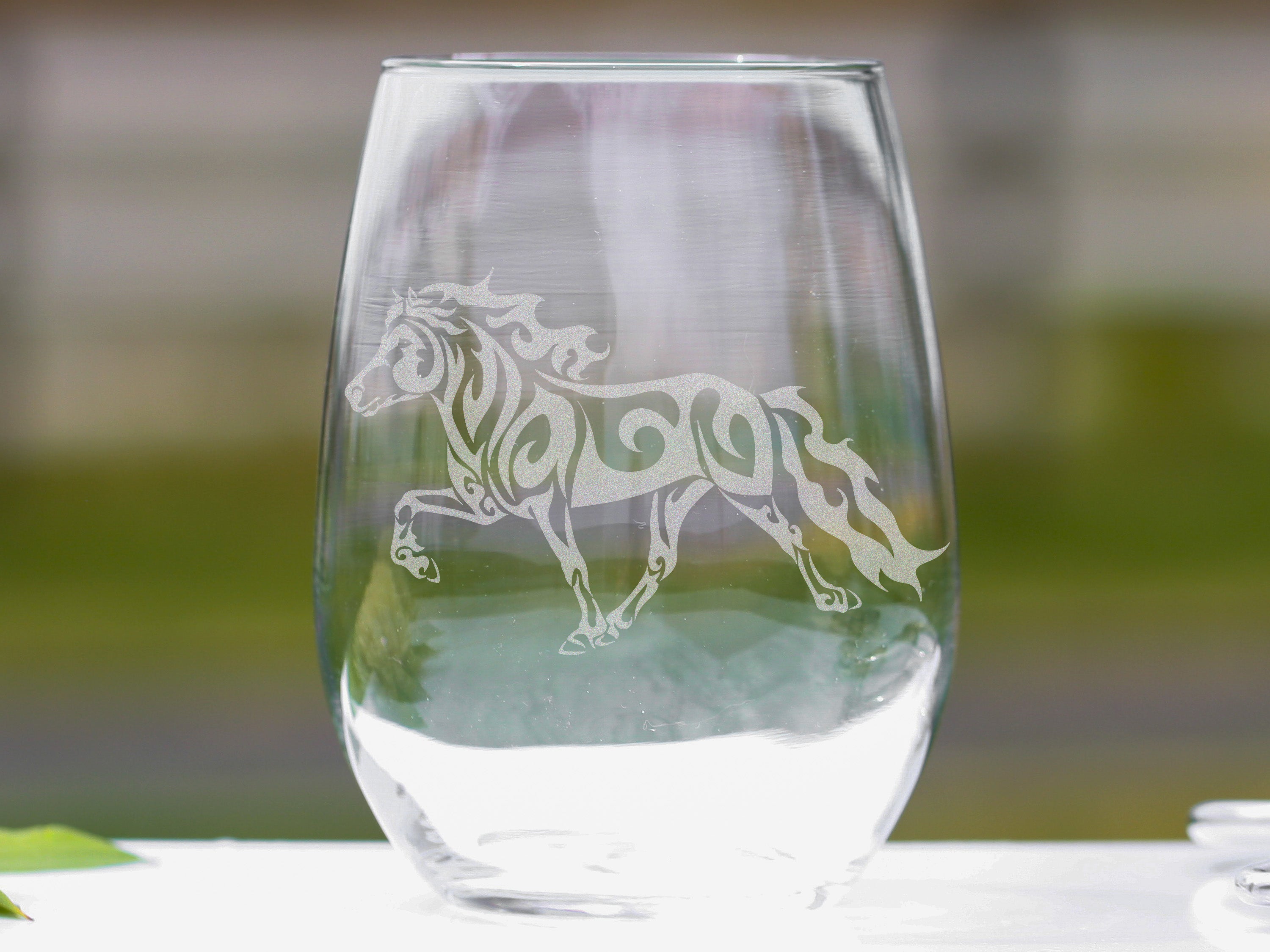 Set of elegant stemless wine glasses featuring laser engraved Icelandic horse design, perfect for wine lovers.