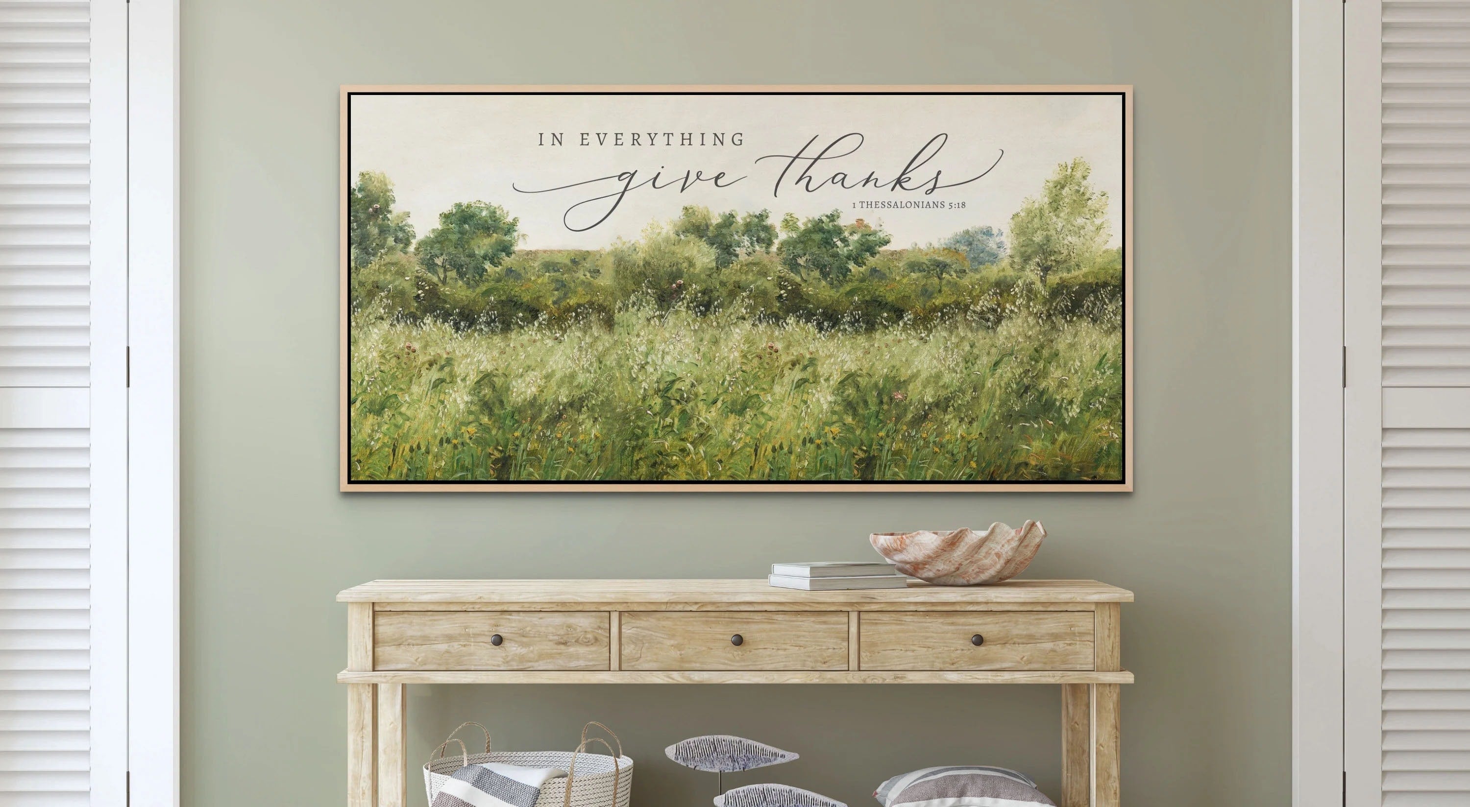 Canvas sign featuring the quote 'In Everything Give Thanks' from 1 Thessalonians 5:18, designed by Camilla Simone, displayed in a cozy home setting.