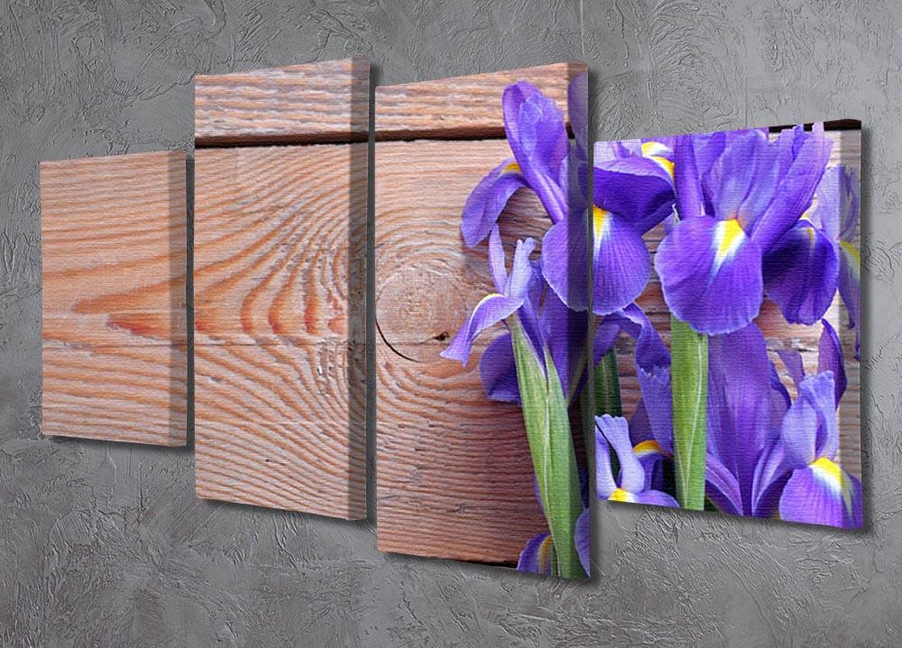 A vibrant iris flower artwork displayed on a rustic wooden background, divided into four equal canvas panels.