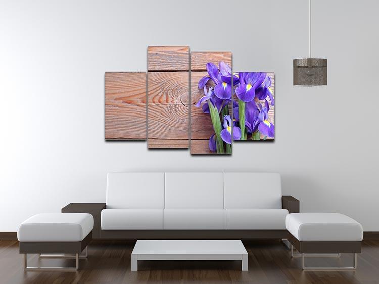 A vibrant iris flower artwork displayed on a rustic wooden background, divided into four equal canvas panels.
