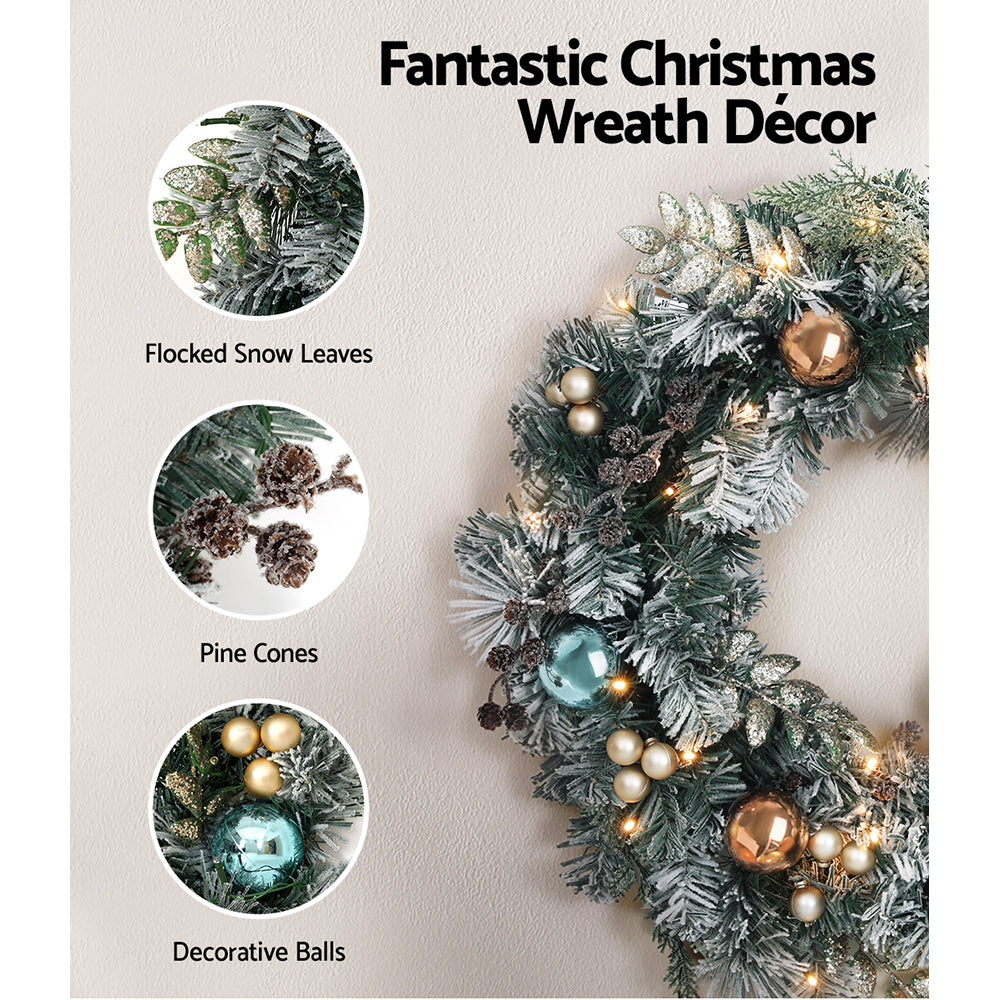 Jingle Jollys Christmas Garland and Wreath set featuring snow-frosted foliage, warm LED lights, and decorative pine cones.
