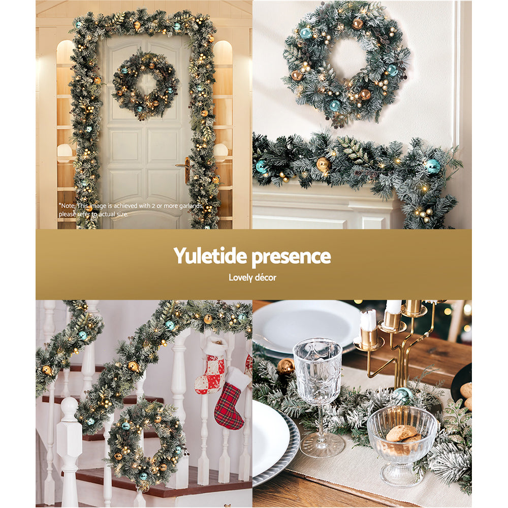 Jingle Jollys Christmas Garland and Wreath set featuring snow-frosted foliage, warm LED lights, and decorative pine cones.