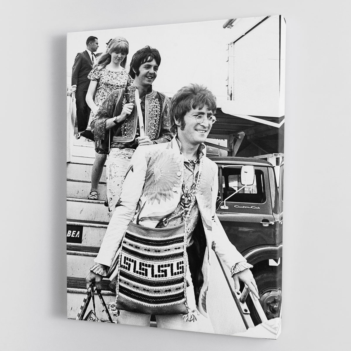 Canvas print featuring John Lennon, Paul McCartney, and Jane Asher getting off a plane, showcasing iconic music history.