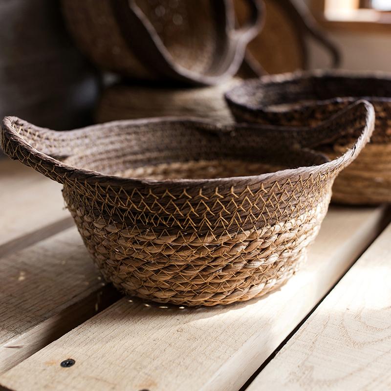 Khaki brown straw basket with handles, showcasing its natural straw texture and elegant design.