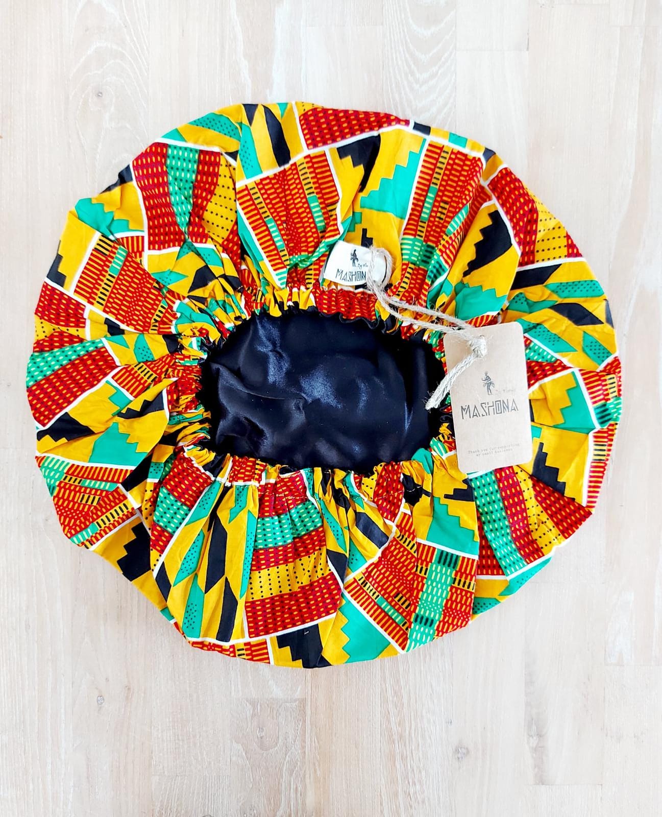 Large African Ankara print satin lined sleep bonnet cap designed for women, featuring vibrant patterns and a soft satin interior for hair protection.