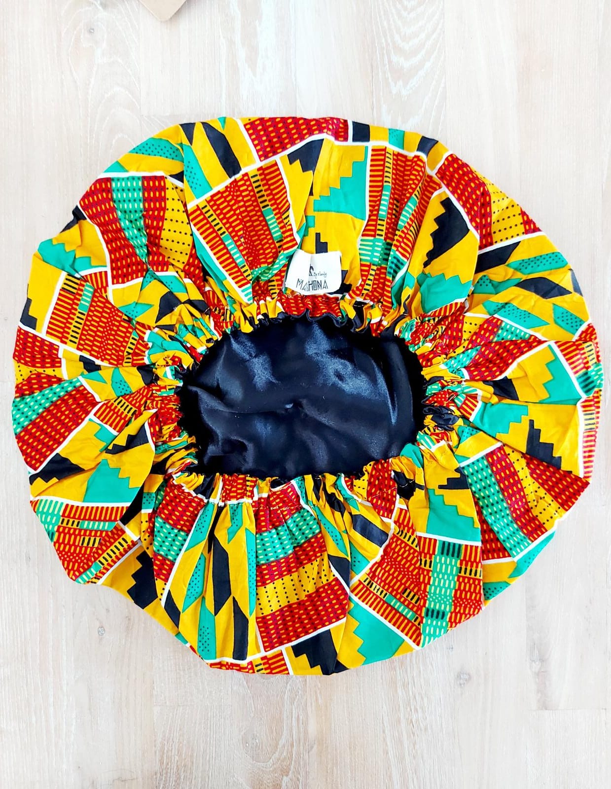 Large African Ankara print satin lined sleep bonnet cap designed for women, featuring vibrant patterns and a soft satin interior for hair protection.