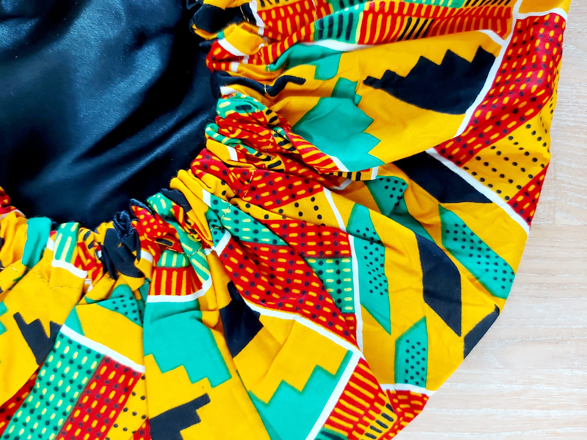 Large African Ankara print satin lined sleep bonnet cap designed for women, featuring vibrant patterns and a soft satin interior for hair protection.