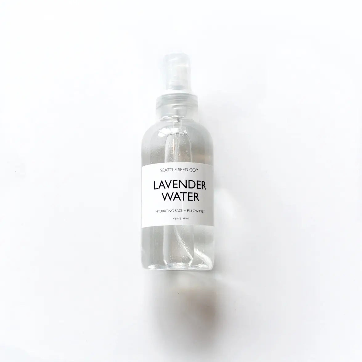 A 4oz bottle of Lavender Face + Pillow Mist with a calming lavender hue, designed for refreshing skin and promoting relaxation.