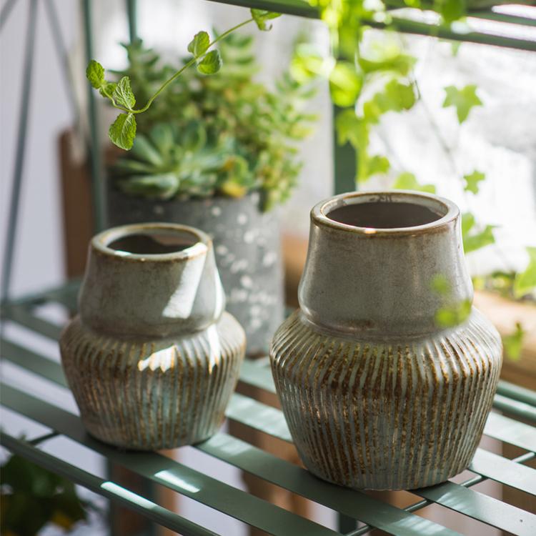 A handmade light blue ceramic vase with a textured glazed finish, showcasing unique color variations and elegant design.