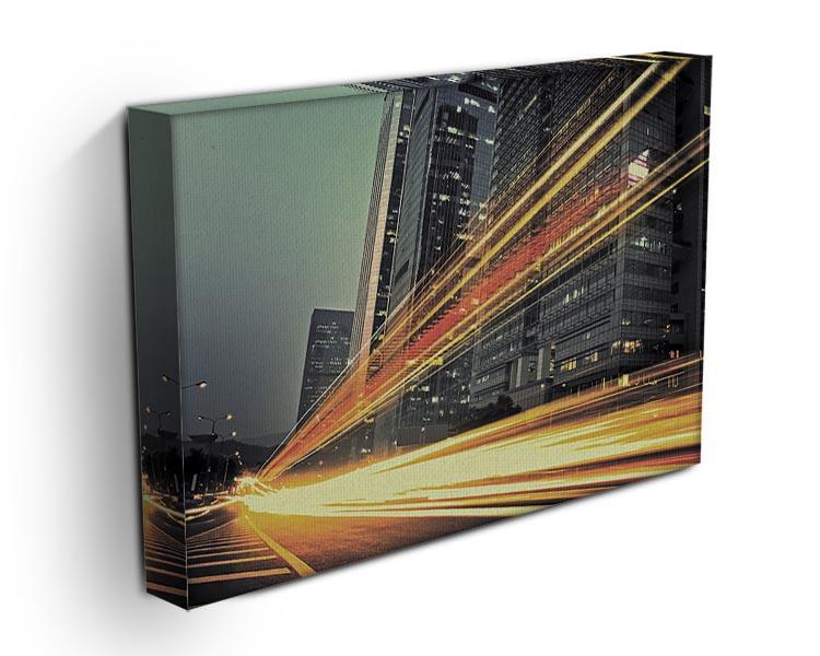 A vibrant canvas print featuring light trails around a modern building, showcasing dynamic urban architecture.