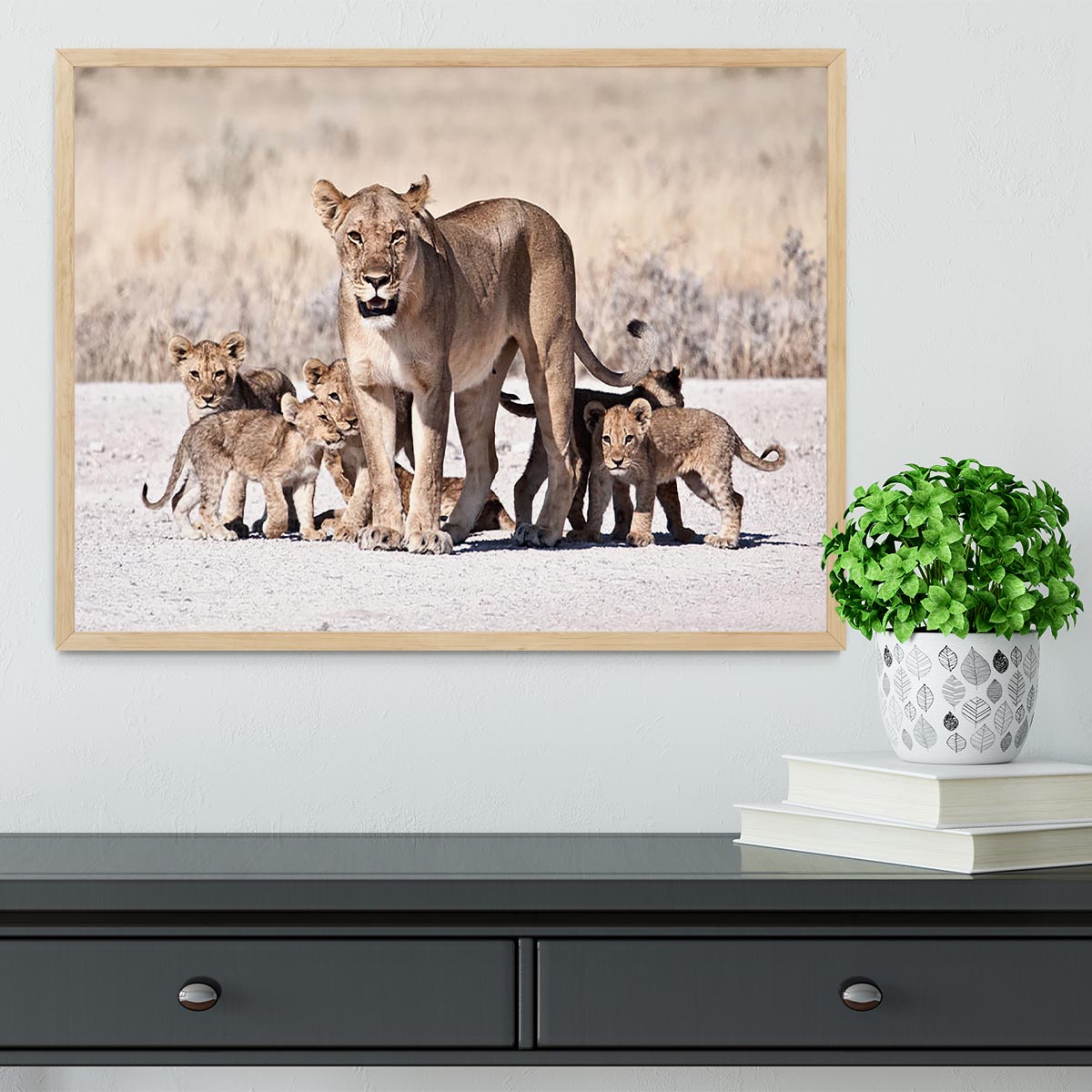 A beautifully framed print of a lioness with her cubs, showcasing vibrant colors and intricate details.