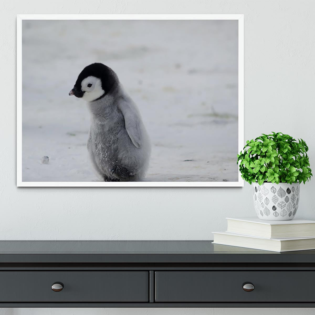 A beautifully framed print of a lone penguin chick, showcasing its adorable features and vibrant colors, set in a handmade frame.