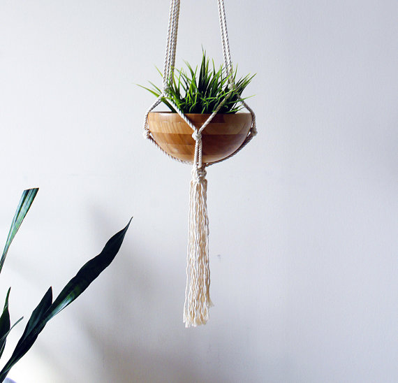 A beautifully handcrafted macrame plant hanger made from 100% natural cotton rope, showcasing a stylish design with tassels, perfect for indoor plant display.