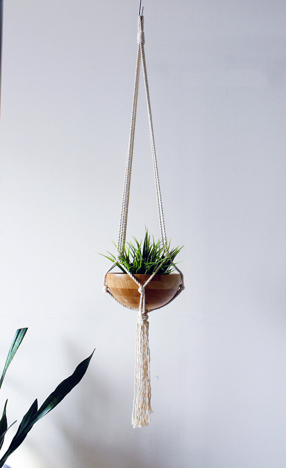 A beautifully handcrafted macrame plant hanger made from 100% natural cotton rope, showcasing a stylish design with tassels, perfect for indoor plant display.
