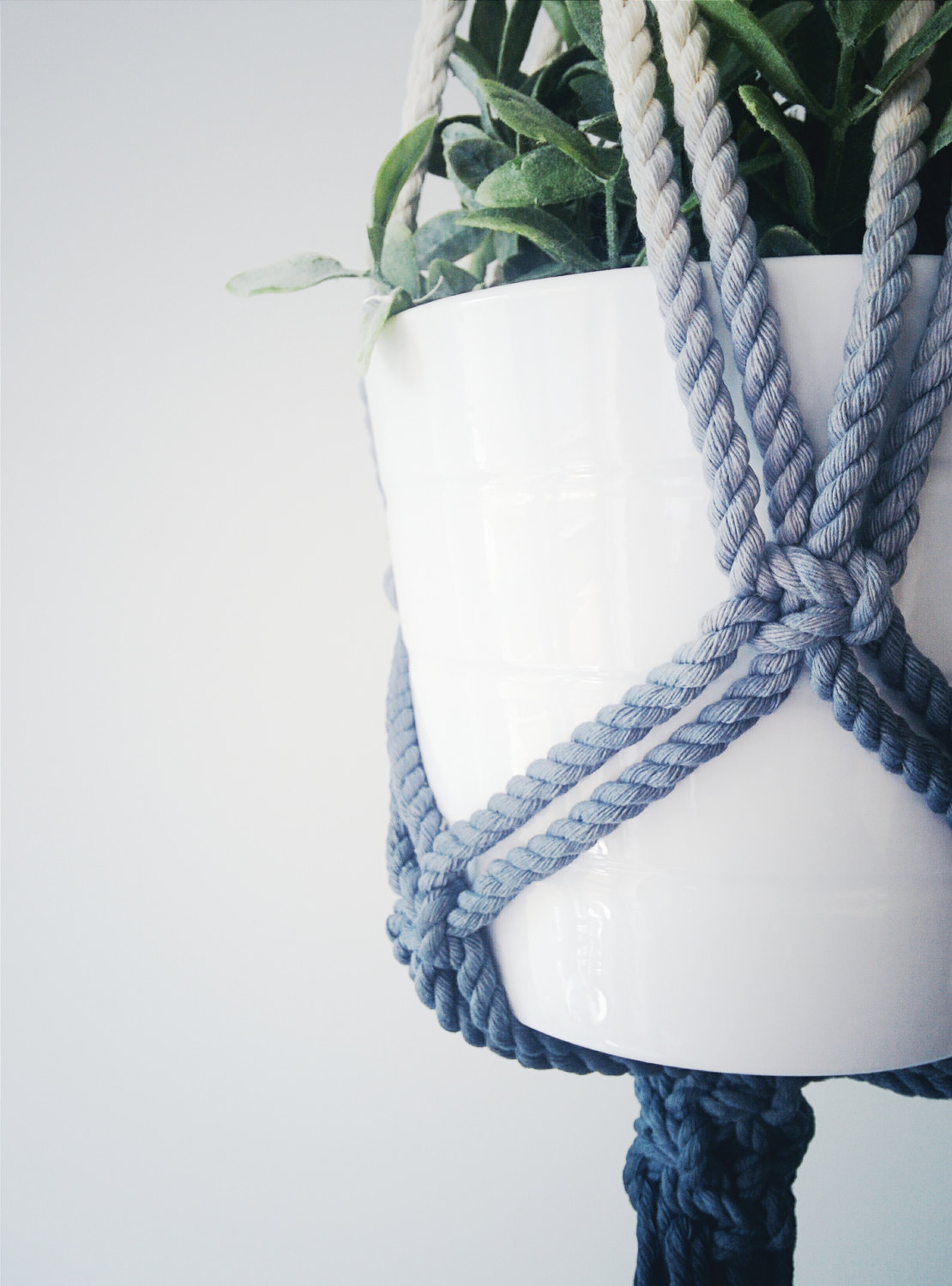 Handmade macrame plant hanger in dark blue, showcasing a stylish design with 100% cotton cord and stainless steel ring, perfect for indoor plants.