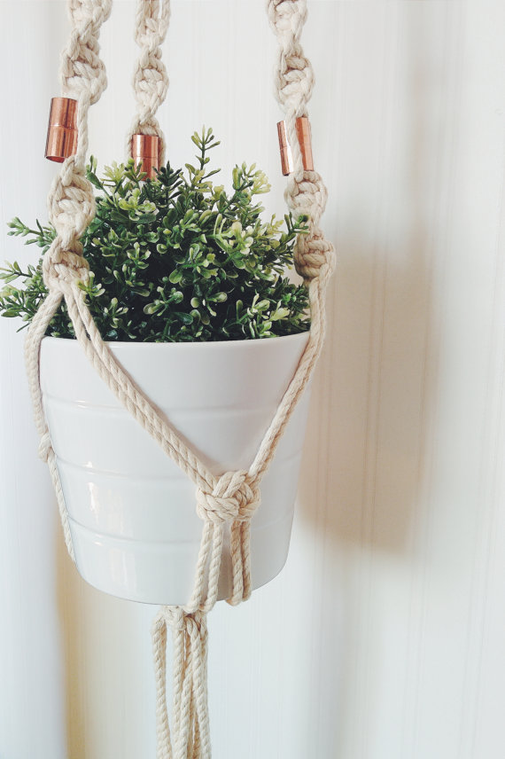 A beautifully handcrafted macrame plant hanger made from 100% cotton rope, showcasing a potted plant suspended elegantly, perfect for indoor or outdoor decor.