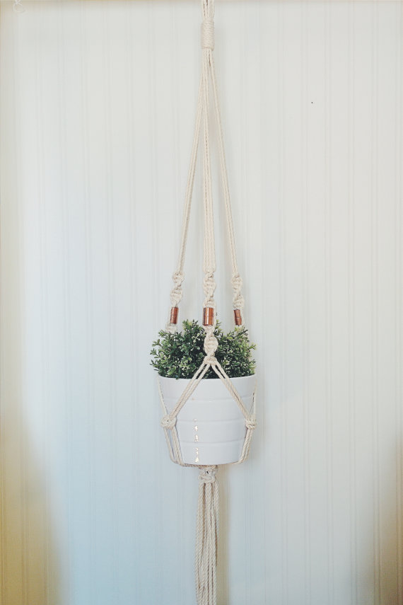 A beautifully handcrafted macrame plant hanger made from 100% cotton rope, showcasing a potted plant suspended elegantly, perfect for indoor or outdoor decor.