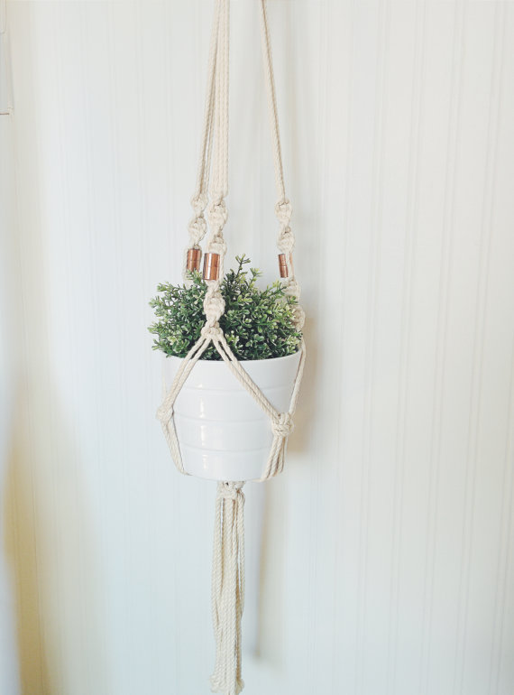 A beautifully handcrafted macrame plant hanger made from 100% cotton rope, showcasing a potted plant suspended elegantly, perfect for indoor or outdoor decor.