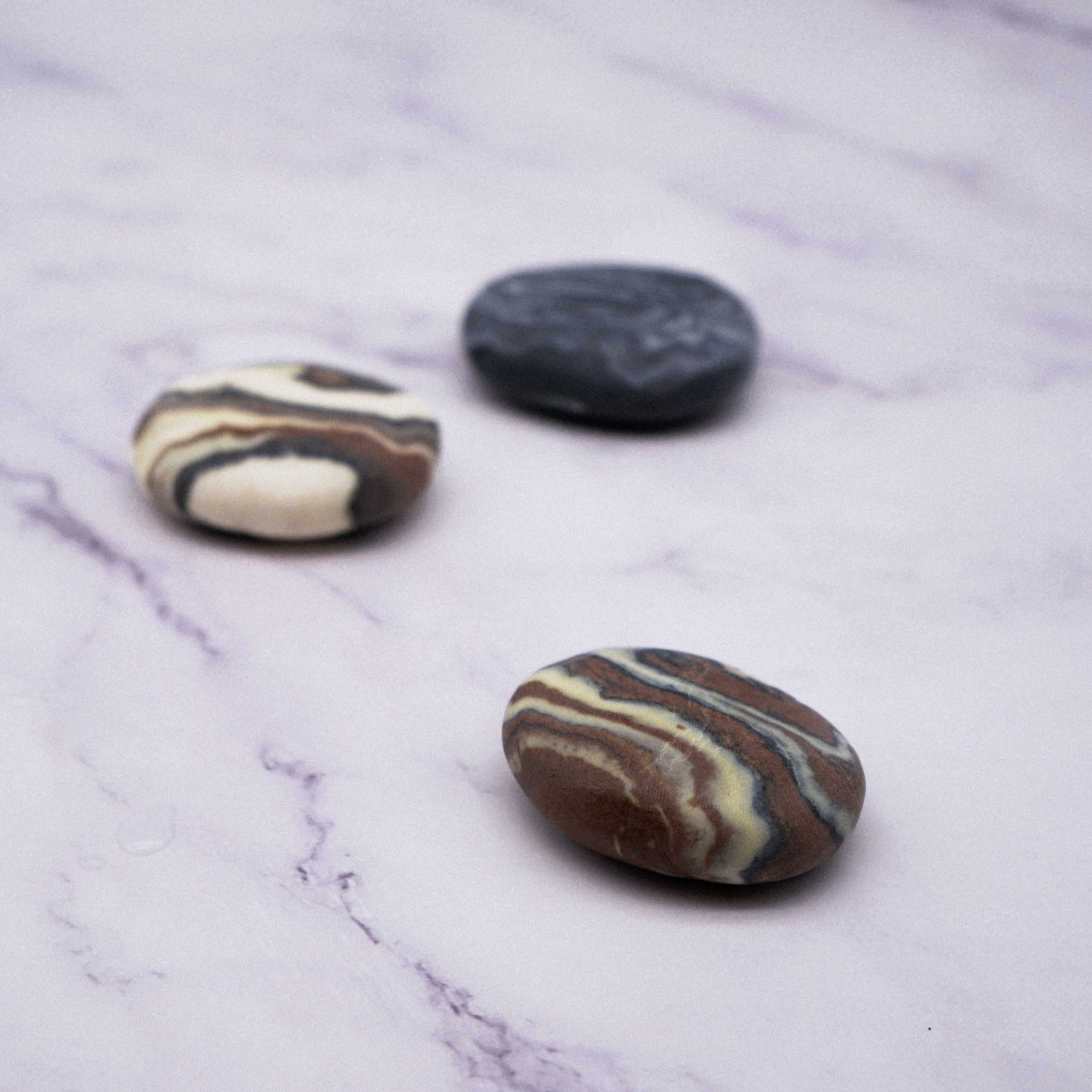 A collection of unique Marble Effect Pebble Soaps in various colors and designs, showcasing their natural and handmade quality.