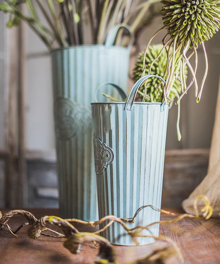 Set of three decorative metal pots with handles, featuring an antique paint finish in green and gray colors, perfect for flowers and garden use.