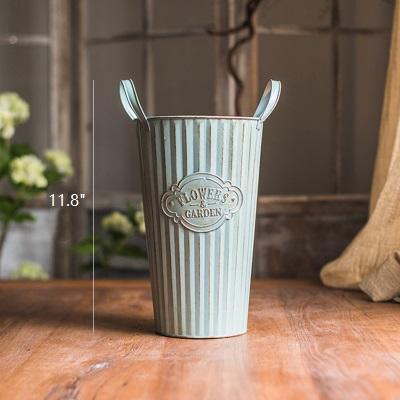 Set of three decorative metal pots with handles, featuring an antique paint finish in green and gray colors, perfect for flowers and garden use.