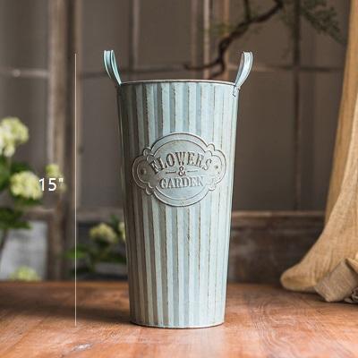 Set of three decorative metal pots with handles, featuring an antique paint finish in green and gray colors, perfect for flowers and garden use.