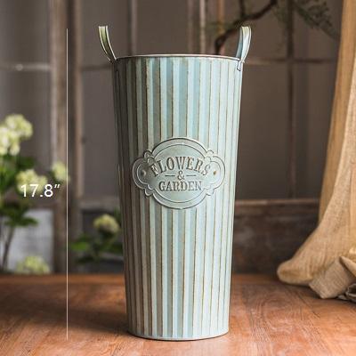 Set of three decorative metal pots with handles, featuring an antique paint finish in green and gray colors, perfect for flowers and garden use.