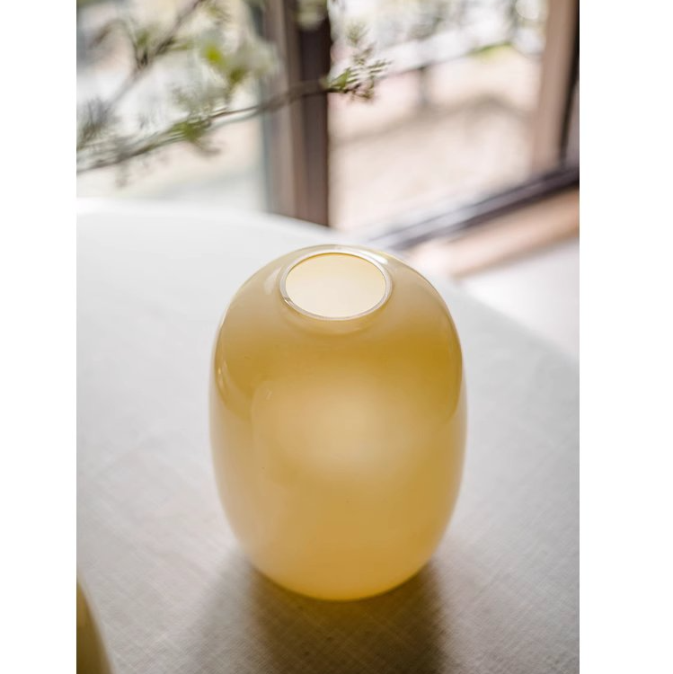 A modern hand-blown glass vase in vibrant yellow, showcasing its elegant design and perfect for floral arrangements.