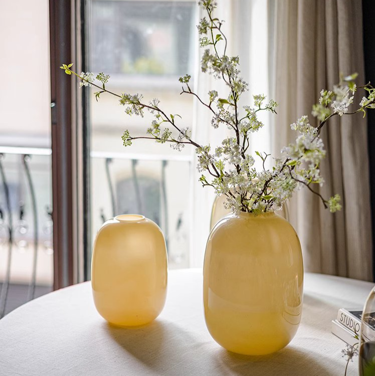 A modern hand-blown glass vase in vibrant yellow, showcasing its elegant design and perfect for floral arrangements.