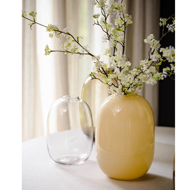 A modern hand-blown glass vase in vibrant yellow, showcasing its elegant design and perfect for floral arrangements.