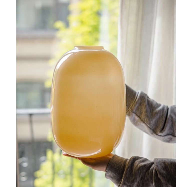 A modern hand-blown glass vase in vibrant yellow, showcasing its elegant design and perfect for floral arrangements.