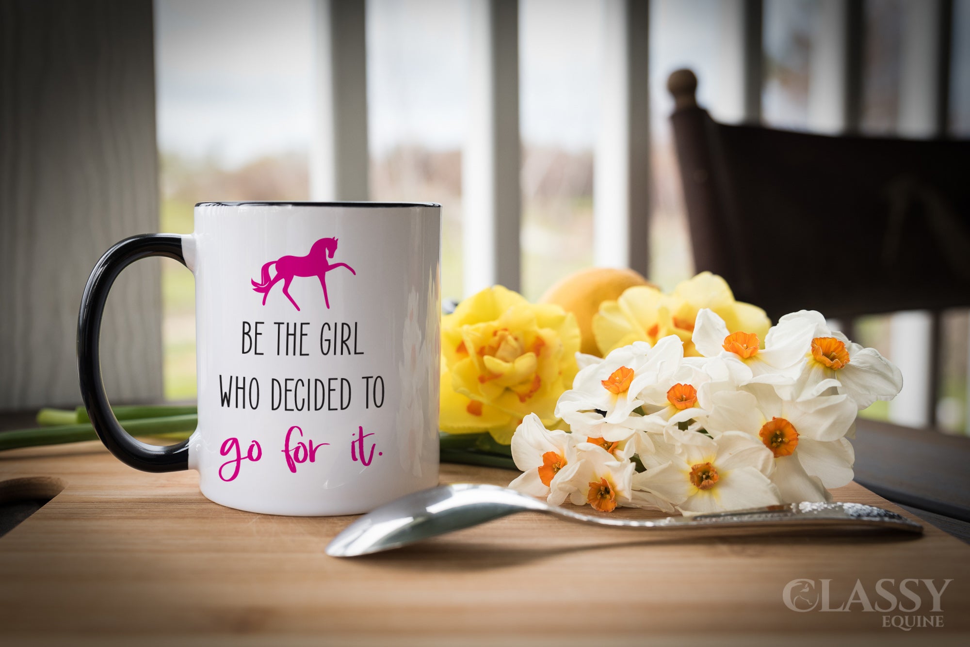 A stylish 11 oz ceramic mug with a black handle and black interior, featuring the inspirational phrase 'Be the girl who decided to go for it'.