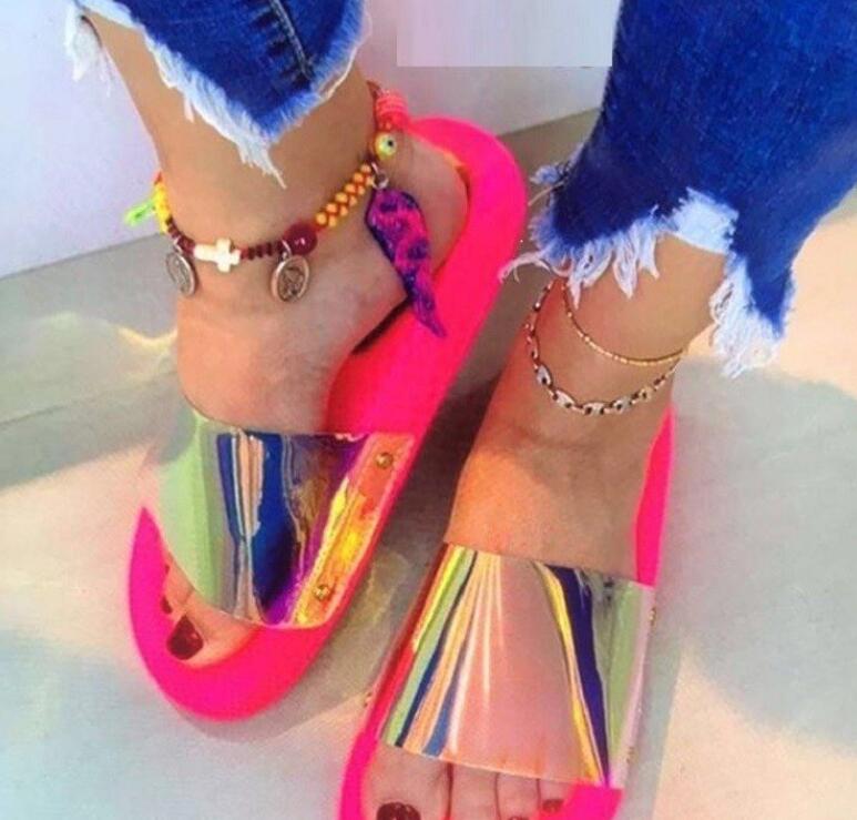 A pair of stylish clear jelly sandals for women, featuring a slip-on design and flat heel, perfect for summer wear.