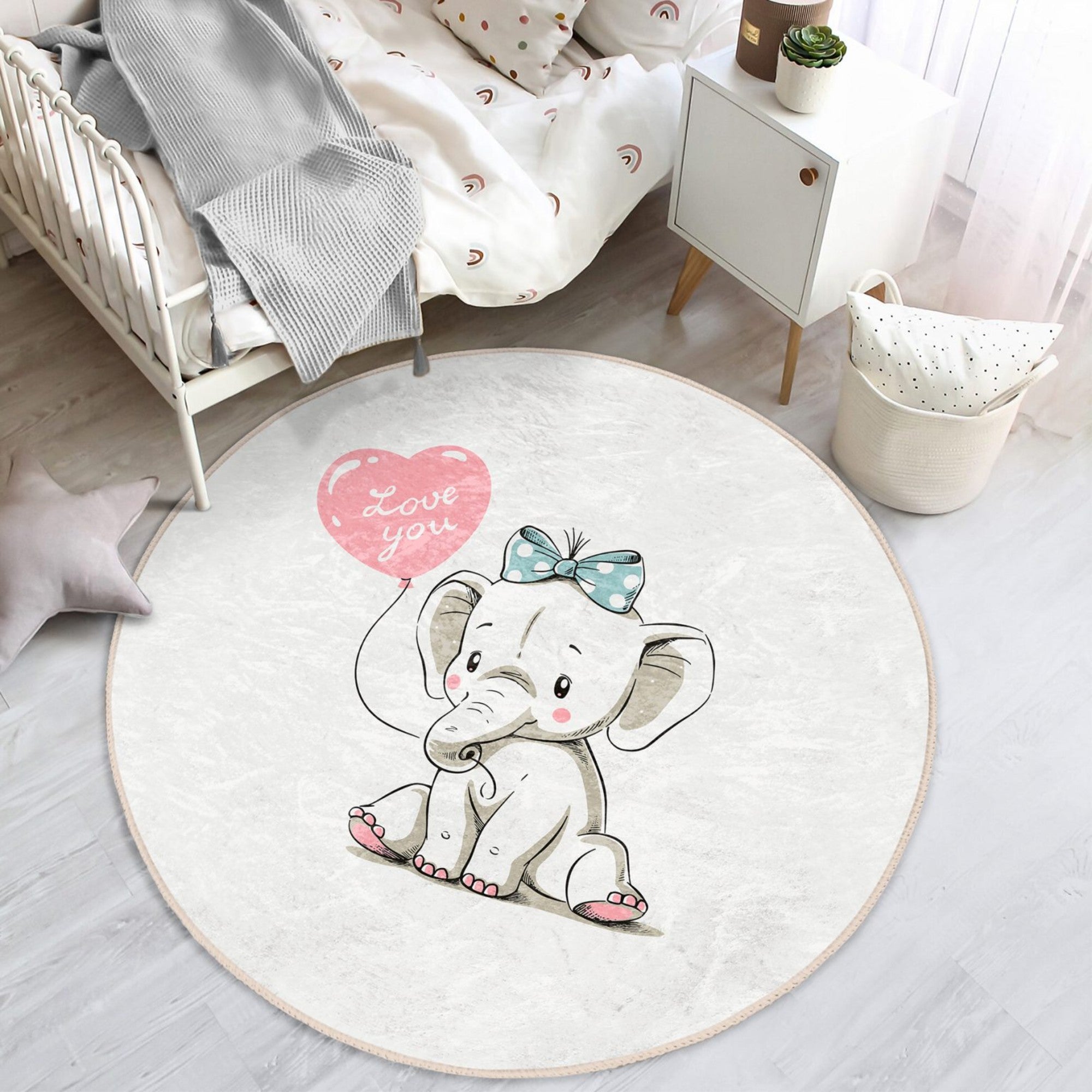 A soft, round nursery rug featuring a charming elephant print, perfect for adding comfort and style to a baby's room.