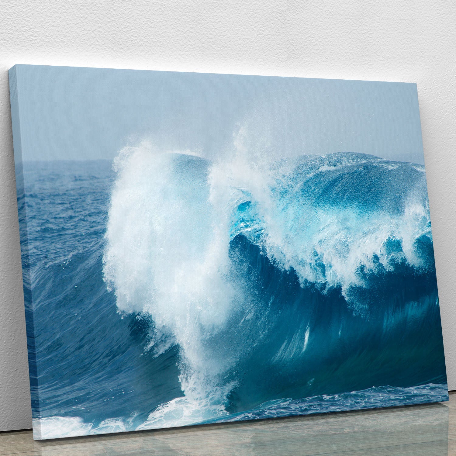 A beautiful canvas print depicting ocean waves breaking against the shore, showcasing vibrant blues and whites.