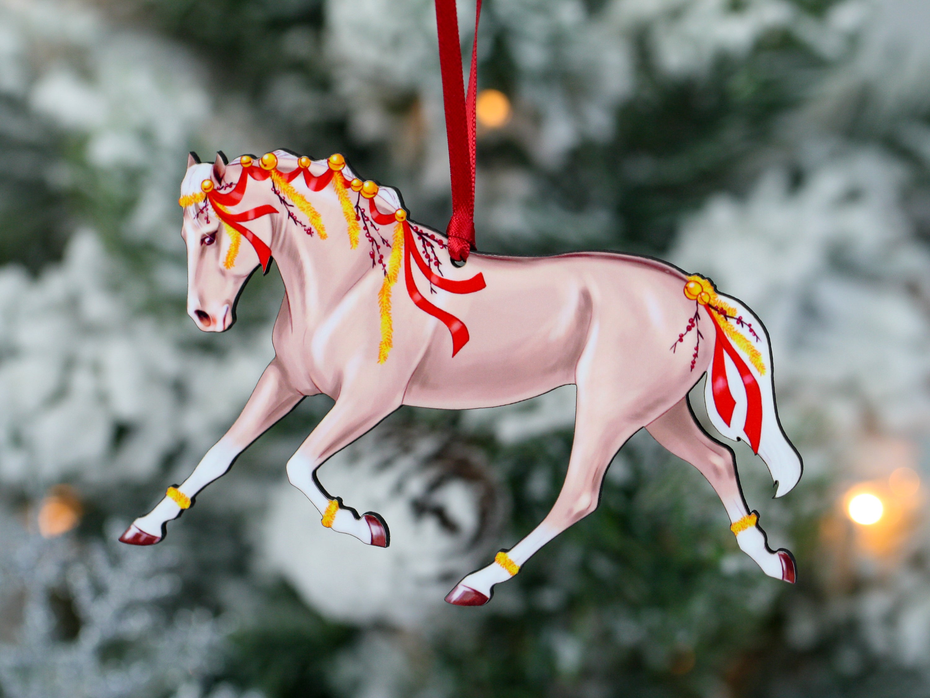 A beautifully crafted Palomino horse ornament with red ribbons and yellow garland, perfect for Christmas decoration.
