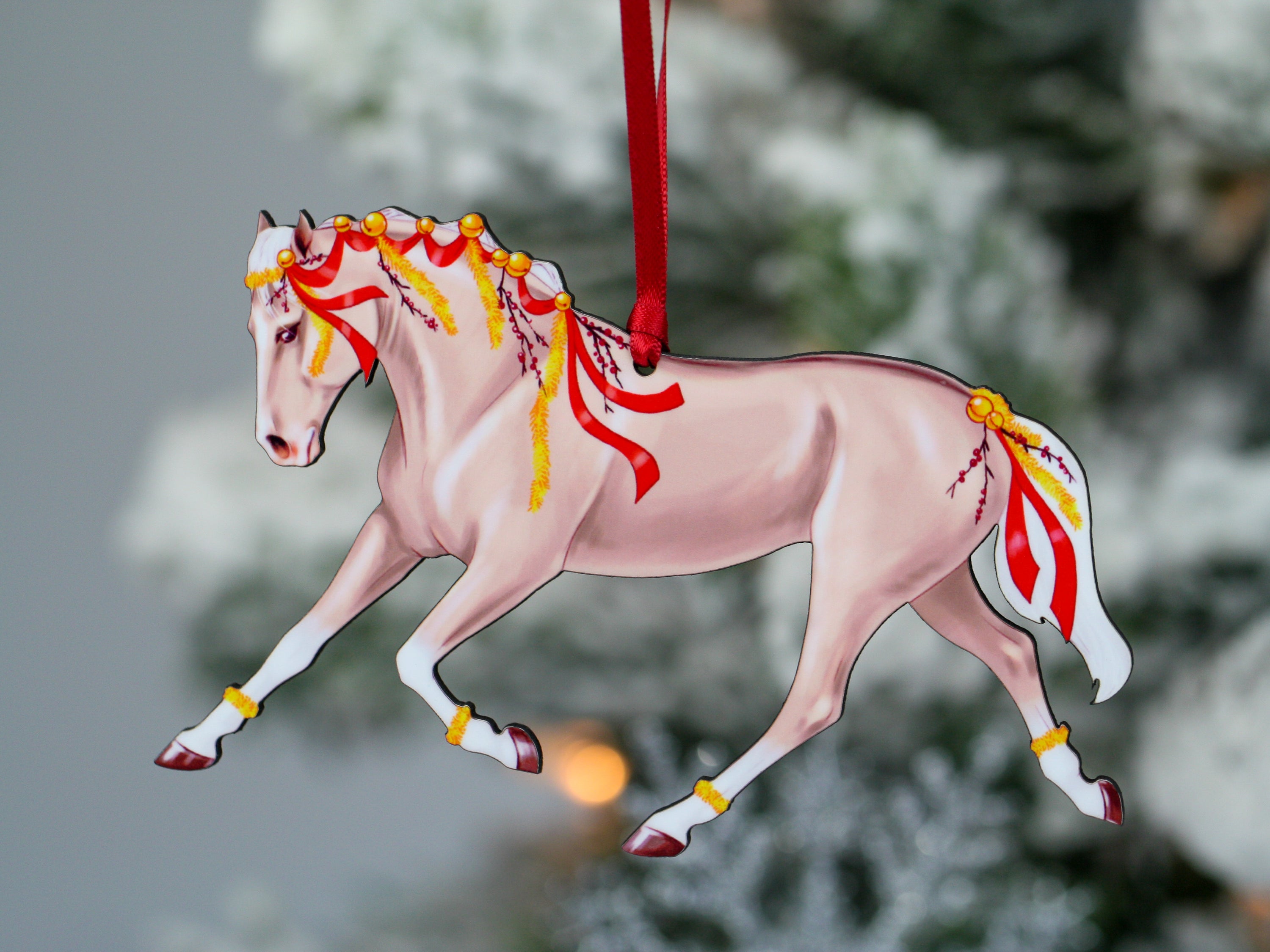 A beautifully crafted Palomino horse ornament with red ribbons and yellow garland, perfect for Christmas decoration.