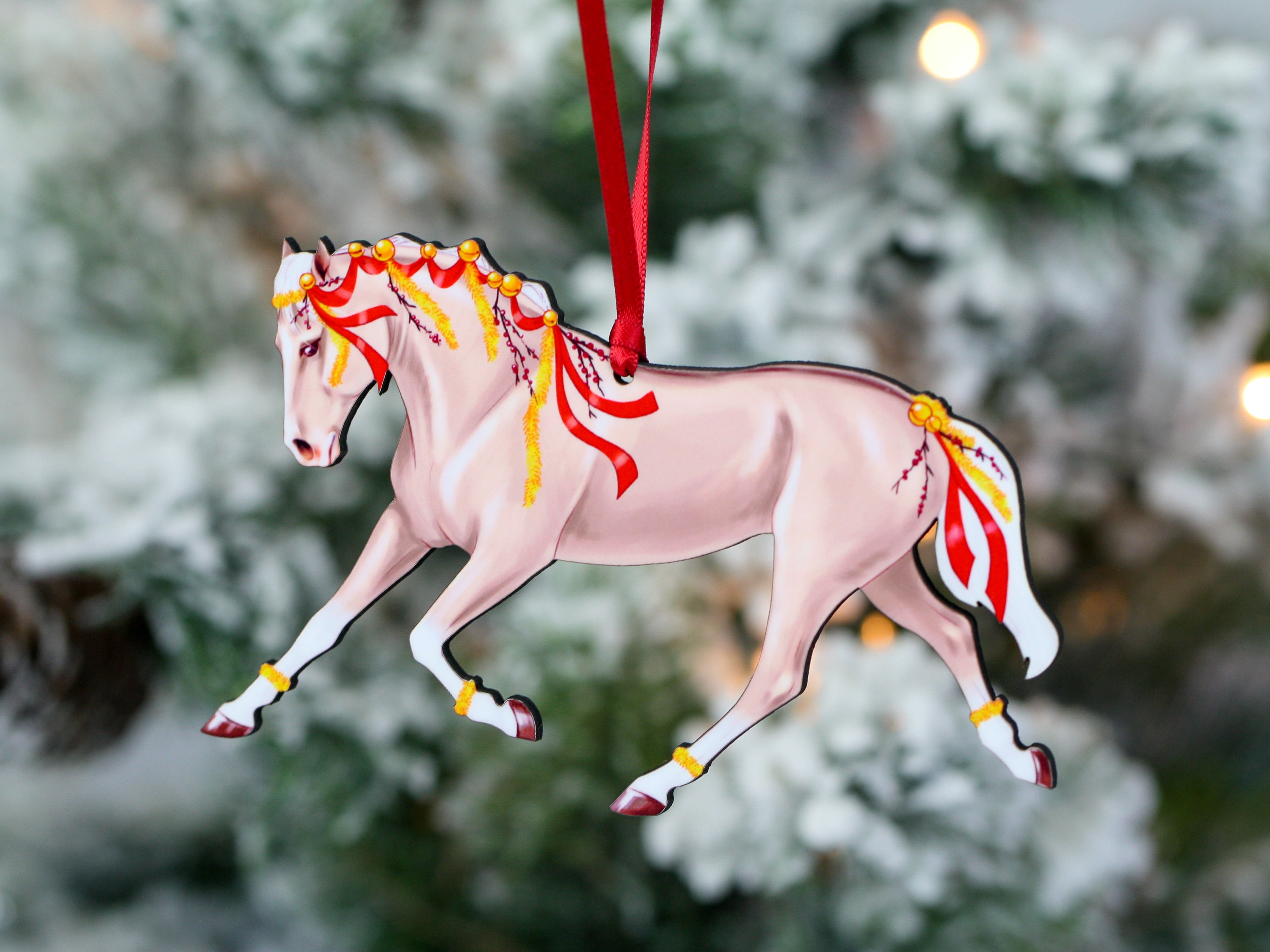 A beautifully crafted Palomino horse ornament with red ribbons and yellow garland, perfect for Christmas decoration.