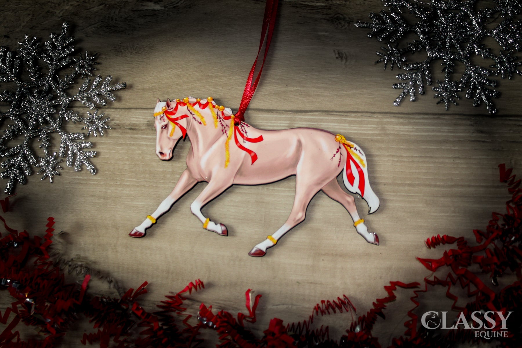 A beautifully crafted Palomino horse ornament with red ribbons and yellow garland, perfect for Christmas decoration.