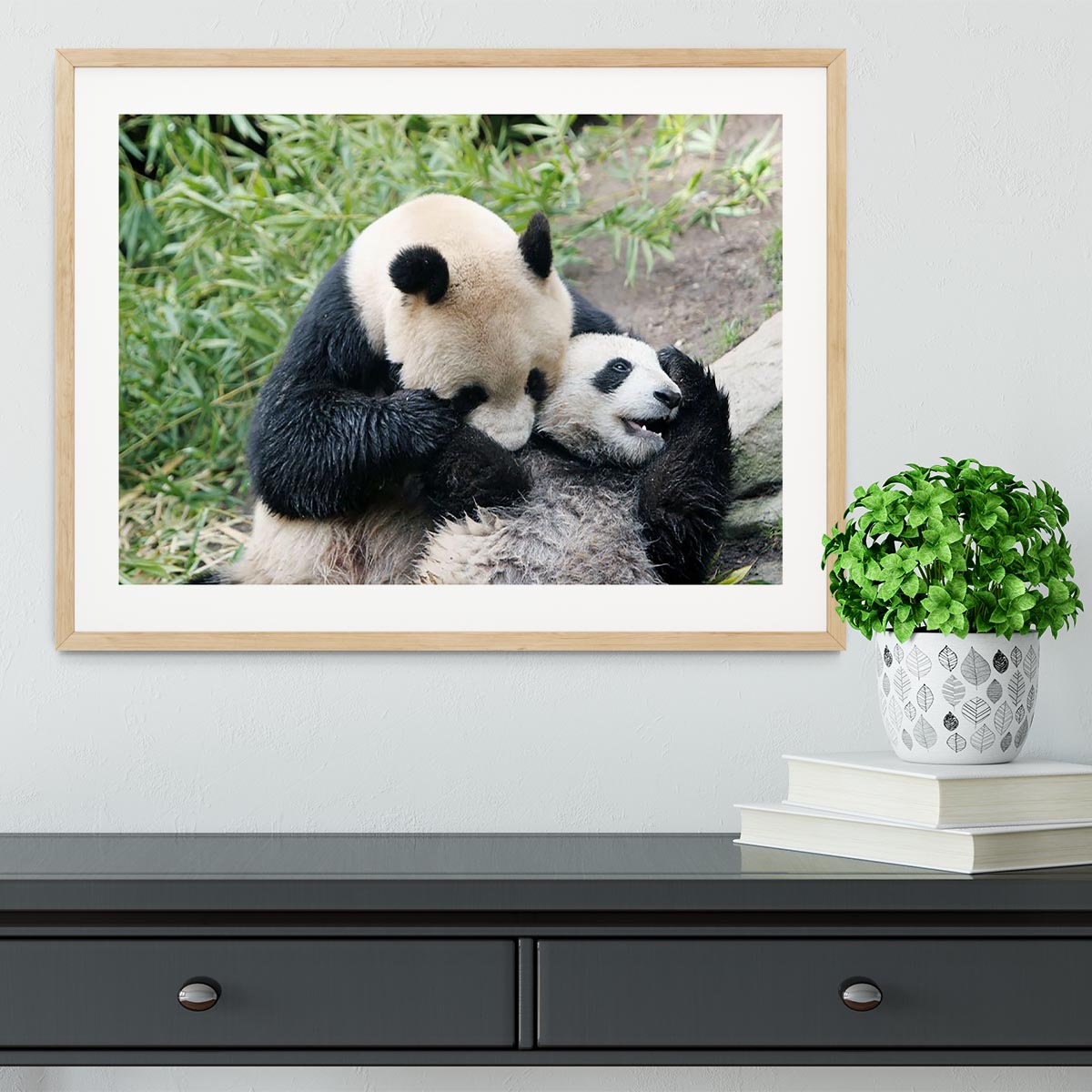 Framed print of a panda bear and her cub, showcasing vibrant colors and intricate details in a handmade frame.