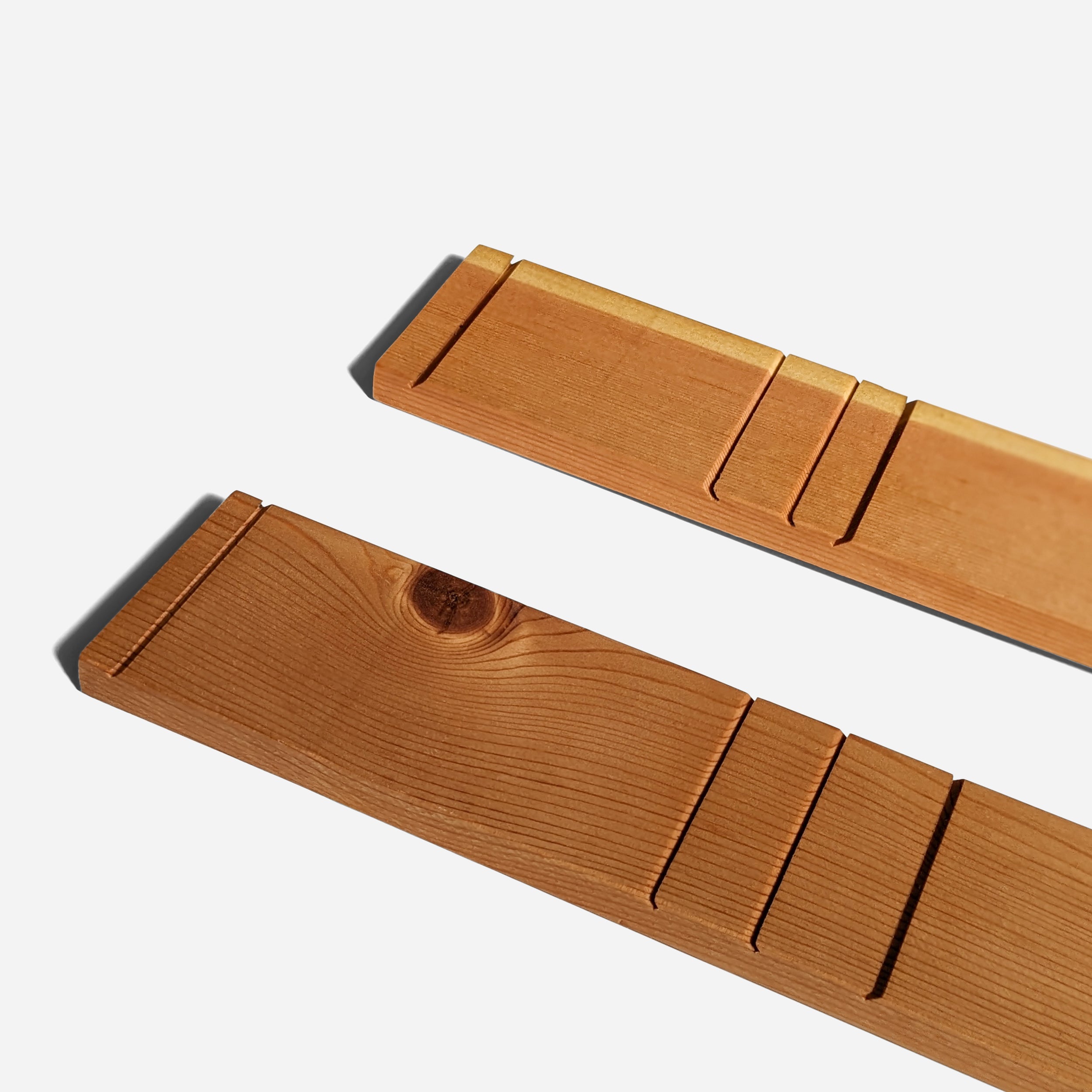 A contemporary wall-mounted photo holder made from sustainable wood, showcasing four photo slots for 3" x 5" or 4" x 6" pictures.