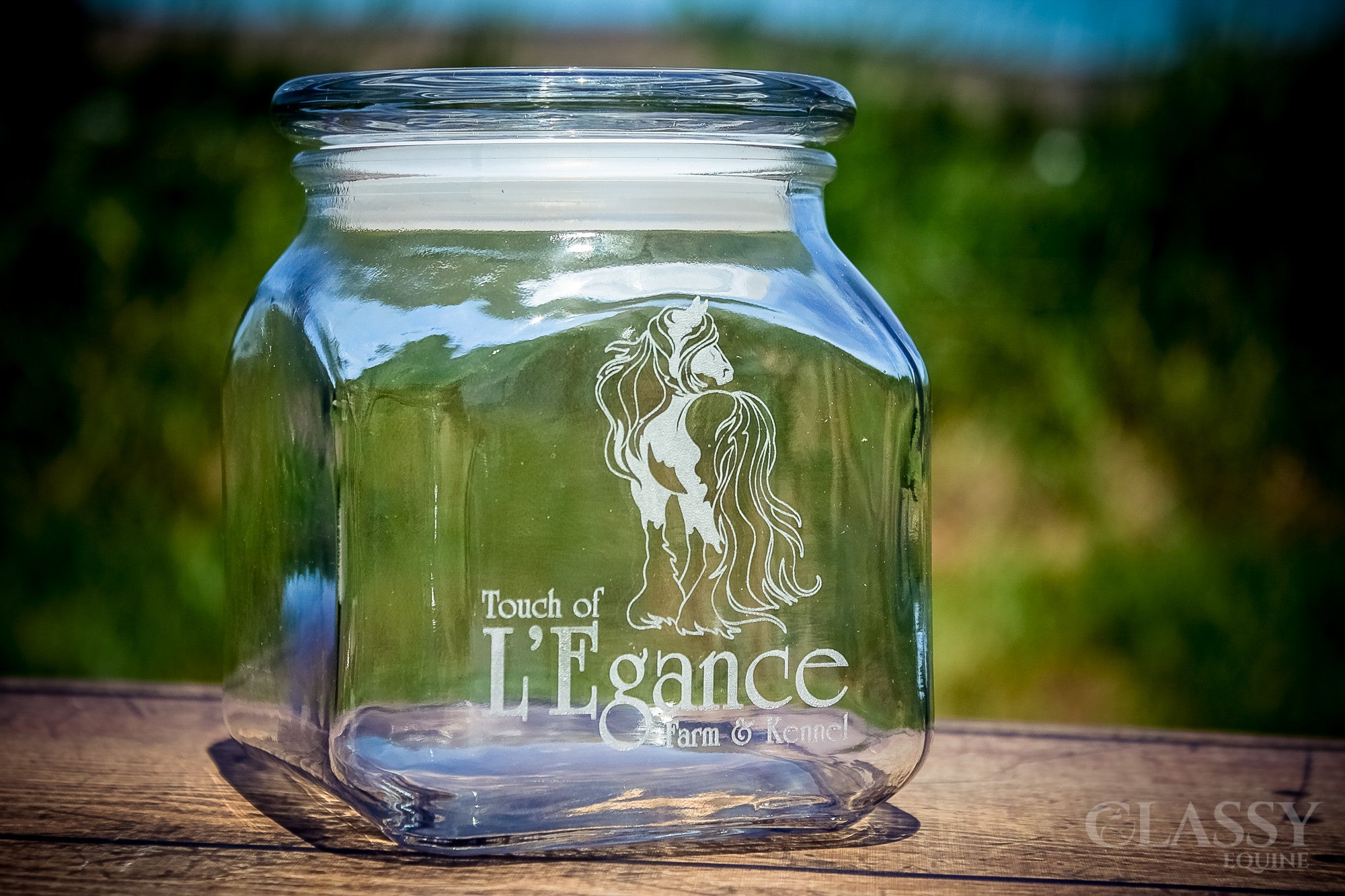 A personalized 20 oz glass jar with a lid, featuring custom engraving options and an elegant equestrian design, perfect for storage or gifting.