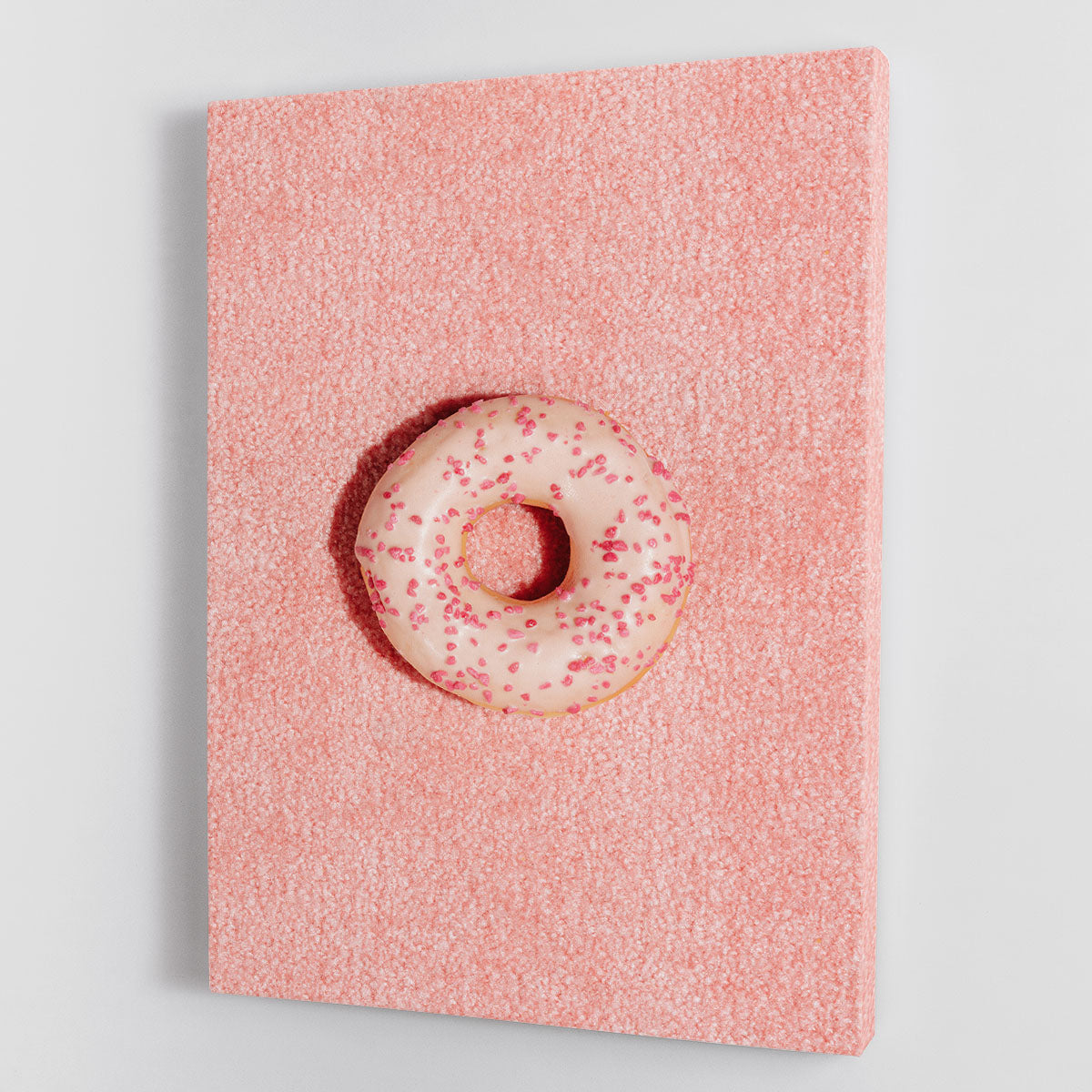 A vibrant pink doughnut canvas print showcasing a whimsical design, perfect for home decor.