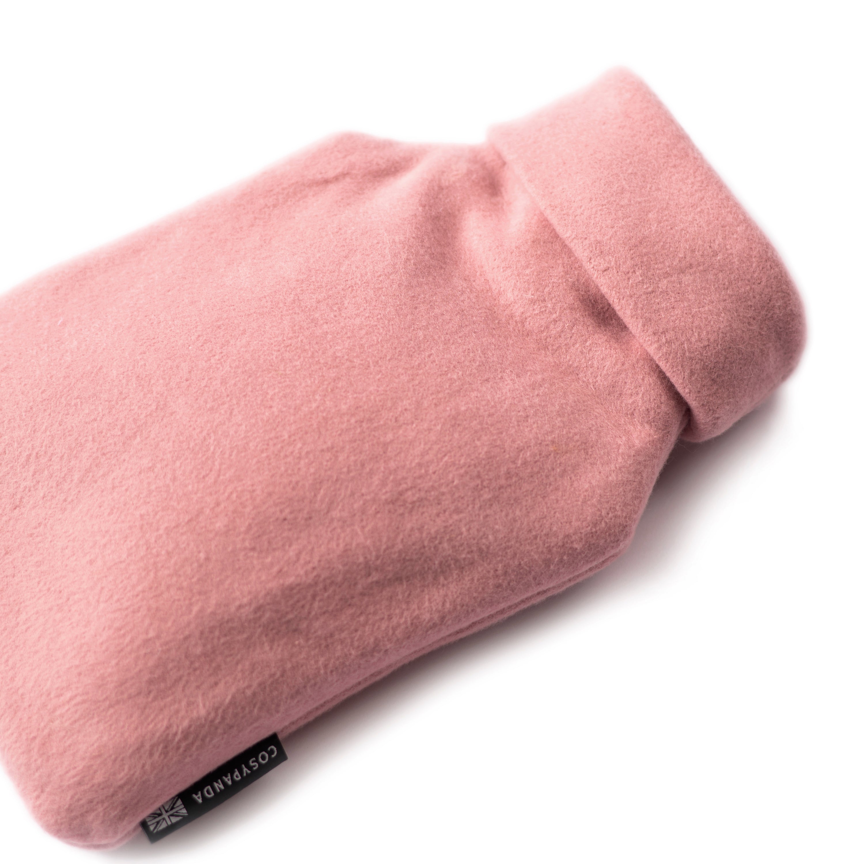 A cozy pink organic cotton hot water bottle with a roll-neck design, handmade in the UK, perfect for warmth and comfort.